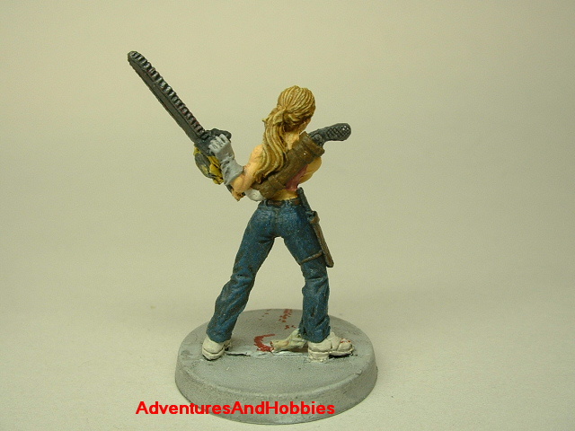 Zombie survivor woman with chainsaw painted figure for role-playing games and table top war games rear view